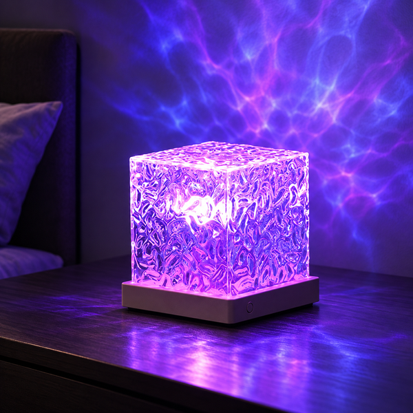 Faceted RGB ripple projector lamp on a dark table with violet-blue ambient glow