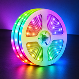 Coiled RGB LED strip reel on a dark background with multicolor LEDs